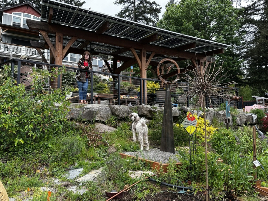 Deborah Nagano and her dog Benny stand near the railing next to the solar canopy at her Camas residence in an undated photo. (Randal Friedman)