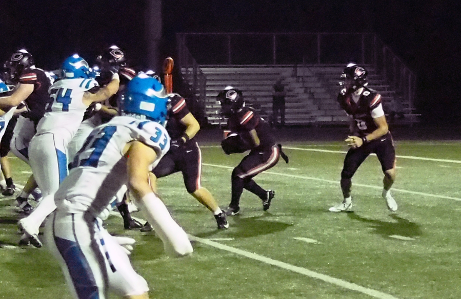 Camas running back Thor Brody, middle, looks for a hole against Coeur d&rsquo;Alene during the non-league game Friday at Doc Harris Stadium. (Jeff Klein/The Columbian)