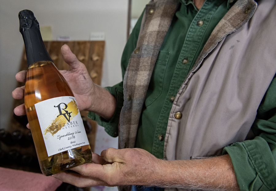 Roger Rezabek of Rezabek Vineyards holds a 2018 bottle of sparkling wine, the first made from all grapes from his estate north of Battle Ground.