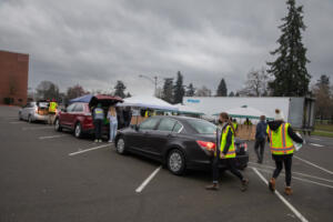 Volunteers collect nonperishable food donations in 2021 at Hudson’s Bay High School in Vancouver. Clark County’s Walk & Knock food drive is changing its name to Drive & Drop and will permanently shift to the drop-off model it used during the COVID-19 pandemic. (The Columbian files)