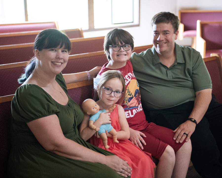 Robyn Kistemaker, from left, Noelle Hively, 5, Lucas Hively, 11, and David Hively sit for a portrait at Messiah Lutheran Church. They adopted Lucas in 2014 and Noelle in 2020. (Taylor Balkom/The Columbian)