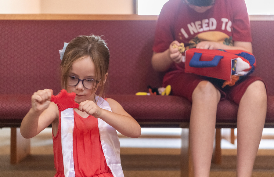 Noelle Hively, 5, left, stretches out a star Sept. 8 at the Pray-Ground area of Messiah Lutheran Church. Sometimes, Noelle and dad David Hively will go and do things that may be loud and crowded, and mom and son will stay home. (Taylor Balkom/The Columbian)