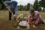 Katherine MacArthur-Krall, left, and Lorie Hoffman scrub the grave marker for Sgt. Fred Campbell, a World War II veteran, at Brush Prairie Cemetery during a recent work party. (James Rexroad for The Columbian)