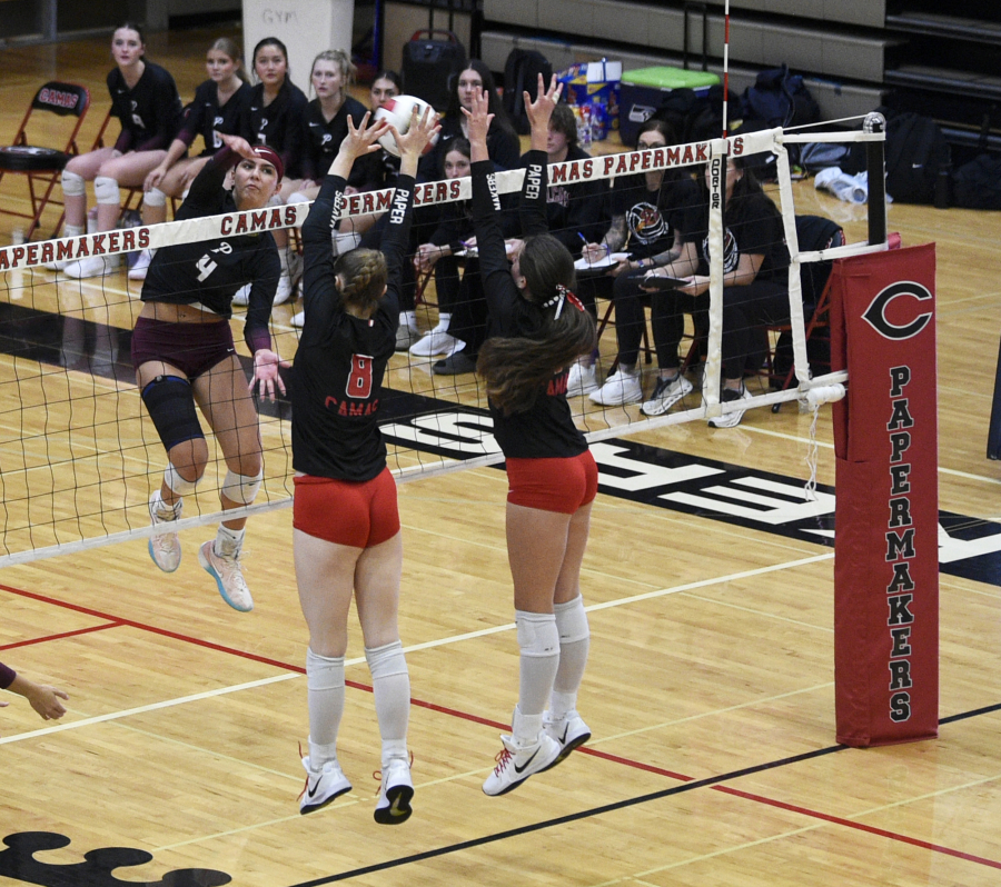 Gracie Jacoby (4) of Prairie attempts a kill over Camas blockers at the net. (Micah Rice/The Columbian)