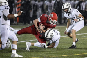 Camas senior Tyson Ruggiero (0) is tackled by Skyview junior Misha Suturin as teammate Jacob Rojas (7) looks on during a 4A Greater St. Helens League game at Doc Harris Stadium in Camas on Friday. Camas won 16-13. (Tim Martinez/The Columbian)