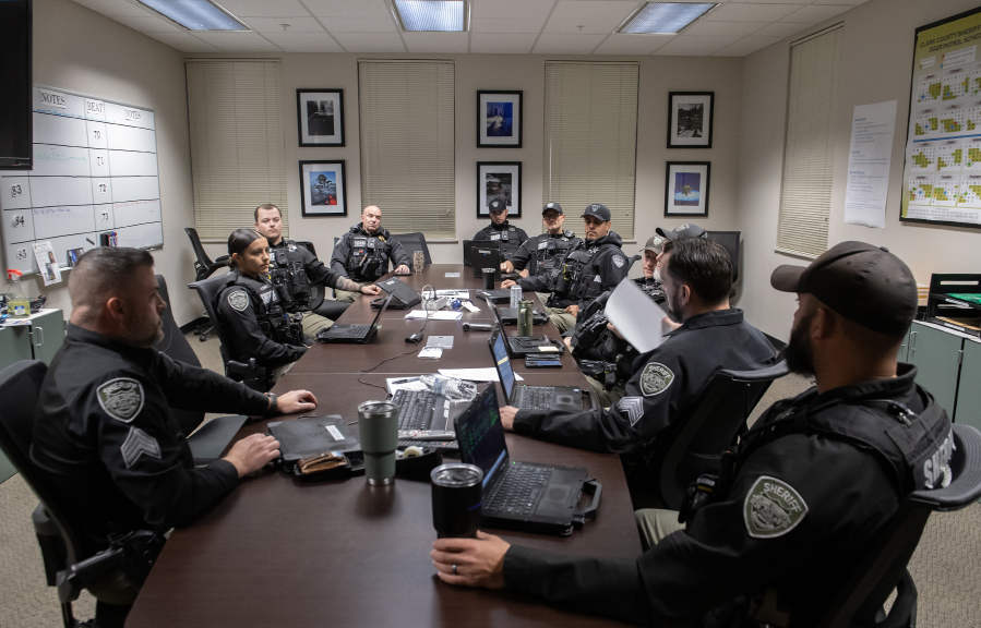 Members of the Clark County Sheriff&rsquo;s Office gather at the west precinct for a briefing before the sun rises on Nov. 7.  A survey by the International Association of Chiefs of Police found agencies have had a harder time recruiting since the COVID-19 pandemic. (Amanda Cowan/The Columbian)