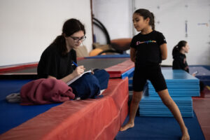 Instructor Bailey Morgan, left, takes notes on Camila Pina’s tumbling skills Sunday during Camas Washougal Youth Cheer practice at VEGA Gymnastics in Washougal. (Taylor Balkom/The Columbian)