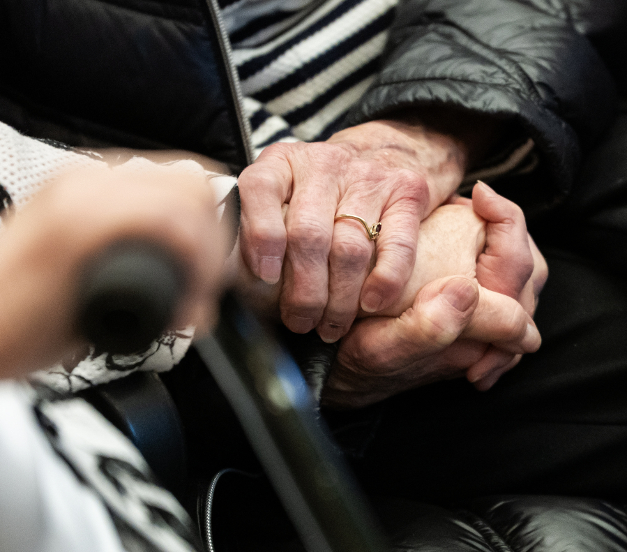 Sharon Wodtke, left, holds hands with her sister Patti Taylor on Wednesday during a Clark County Commission on Aging meeting at the Clark County Public Service Center. Wodtke, a Battle Ground resident, received the commission&rsquo;s sixth annual Silver Citizen Award. (Taylor Balkom/The Columbian)
