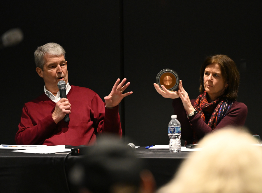During a Monday public meeting at Black Pearl on the Columbia in Washougal, PowerBridge Senior Vice President Chris Hocker, left, speaks while manager Susan Brown holds up a cross section of a cable to be used in the proposed Cascade Renewable Transmission Project. (Taylor Balkom/The Columbian)