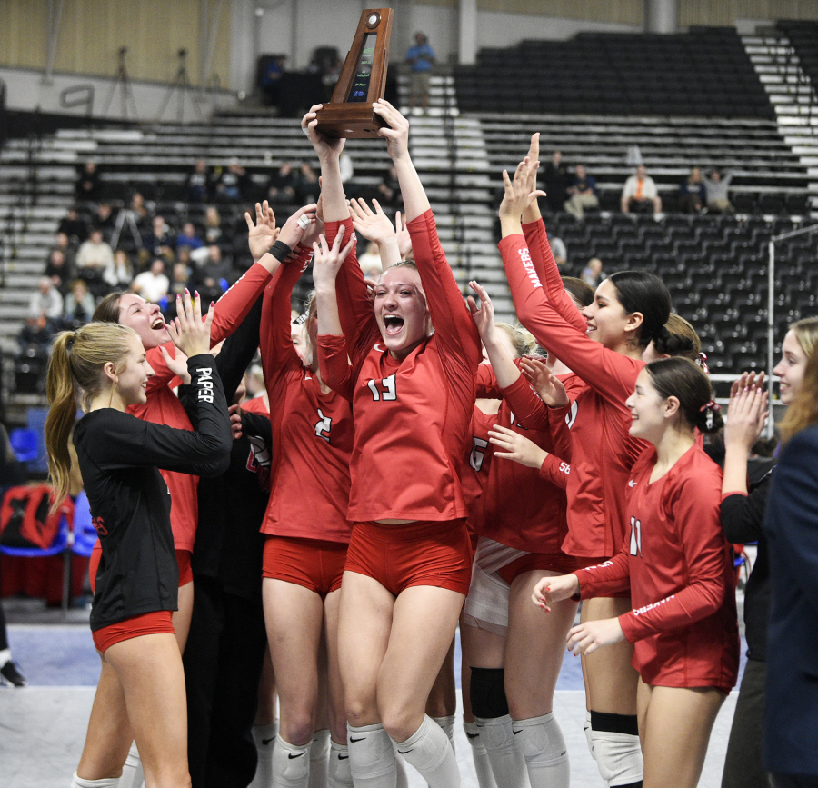 Camas senior Shaylee Stephen, center, holds the fifth-place trophy after a Class 4A state volleyball match against Puyallup on Saturday in Yakima. (Micah Rice/The Columbian)