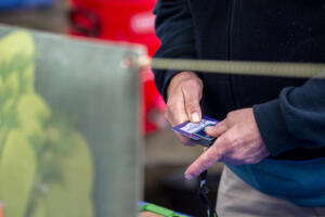 Volunteer Tim Aufmuth processes an EBT card at the information booth at the Vancouver Farmers Market in November 2020. SNAP spending at the market fell Saturday, as federal funding for the food assistance program ran dry. (The Columbian files)