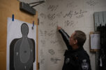 Camas Police Sgt. David Chaney points to a signature on the wall of the armory Nov. 21 at the Camas Police Department headquarters. (Taylor Balkom/The Columbian)