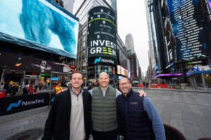 Jim Campbell, Invest Green’s chief financial officer; Andrew McLean, the company’s CEO; and Mike Krawchuk, chief business development officer, stand in New York City’s Times Square in front of the Nasdaq billboard after their first initial public offering. (Photo contributed by Invest Green)