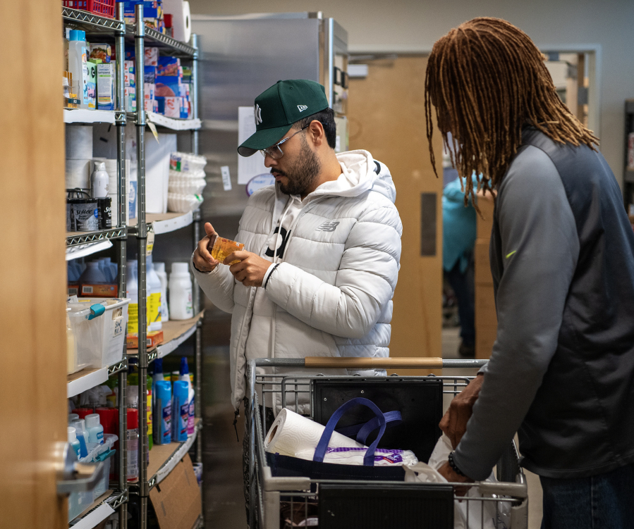 Martha&rsquo;s Pantry client Alejandro Navarro, center, goes browsing on a recent Tuesday morning, accompanied by volunteer Ron Shoals.
Taylor Balkom/The Columbian