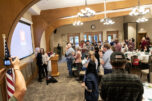 A room stands and applauds as Northwest Battle Buddies&rsquo; 300th service dog, Missy, at left, is given to a veteran Friday during a Northwest Battle Buddies graduation ceremony at Royal Oaks Country Club in Vancouver. (Taylor Balkom/The Columbian)