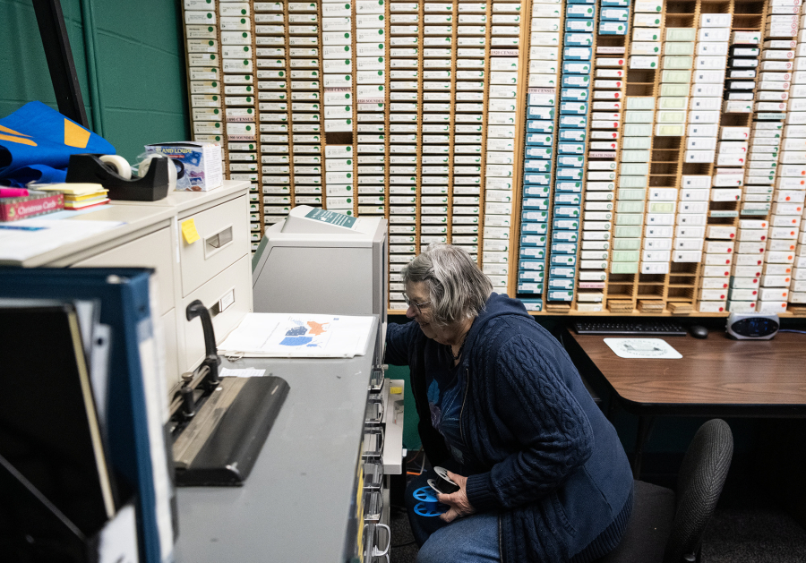 Clark County Genealogical Society member Jane Germann works to put a Lacamas News microfilm reel into a projector Friday at the Clark County Genealogical Society. The Camas Public Library recently donated its historical newspaper microfilm collection to the organization. (Taylor Balkom/The Columbian)