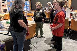 Author Dawn Shipman, left, speaks with student Joshua Sloop and Washougal School District highly capable coordinator Kathlynn Sloop during the Washougal School District&rsquo;s Night with the Authors event Nov. 12 at Washougal High School. (Contributed by the Washougal School District)
