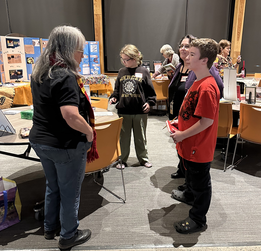 Author Dawn Shipman, left, speaks with student Joshua Sloop and Washougal School District highly capable coordinator Kathlynn Sloop during the Washougal School District&rsquo;s Night with the Authors event Nov. 12 at Washougal High School. (Contributed by the Washougal School District)