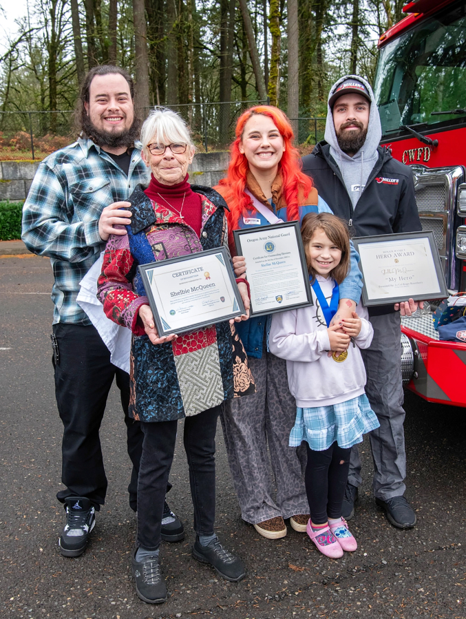 Shelbie McQueen, a third-grader at Woodburn Elementary School in Camas, poses with members of her family for a group photo following an awards presentation held at the school Dec. 3. Shelbie was recognized for her bravery and quick response in helping two members of her community in distress by alerting emergency responders. (John Hughel/Oregon Military Department)