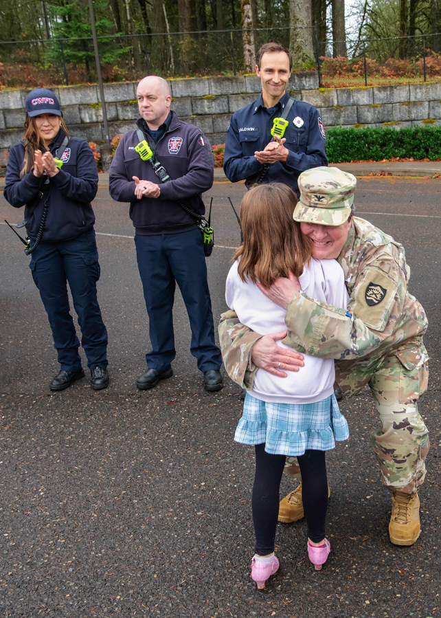 U.S. Army Col. Tannis Mittelbach, director of logistics for the Oregon National Guard, hugs Shelbie McQueen during an awards ceremony at Woodburn Elementary School in Camas on Dec. 3. (John Hughel/Oregon Military Department)