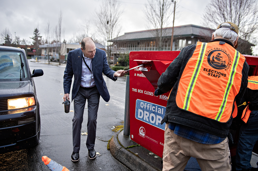 Clark County Auditor Greg Kimsey, left, helps a voter drop off their ballot at the ballot box in downtown Vancouver on March 12, 2024. (amanda cowan/The Columbian files)