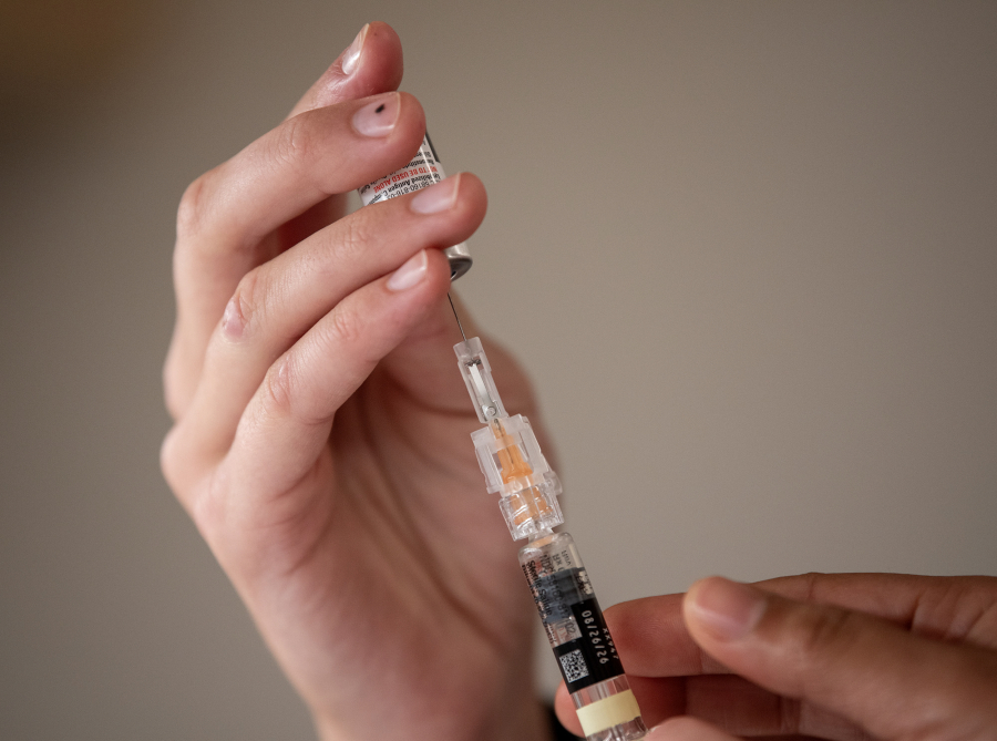 Student medical assistant Megan Kivari extracts a vaccine from a bottle July 23 at Kaiser Cascade Park Medical in Vancouver. (Taylor Balkom/The Columbian files)