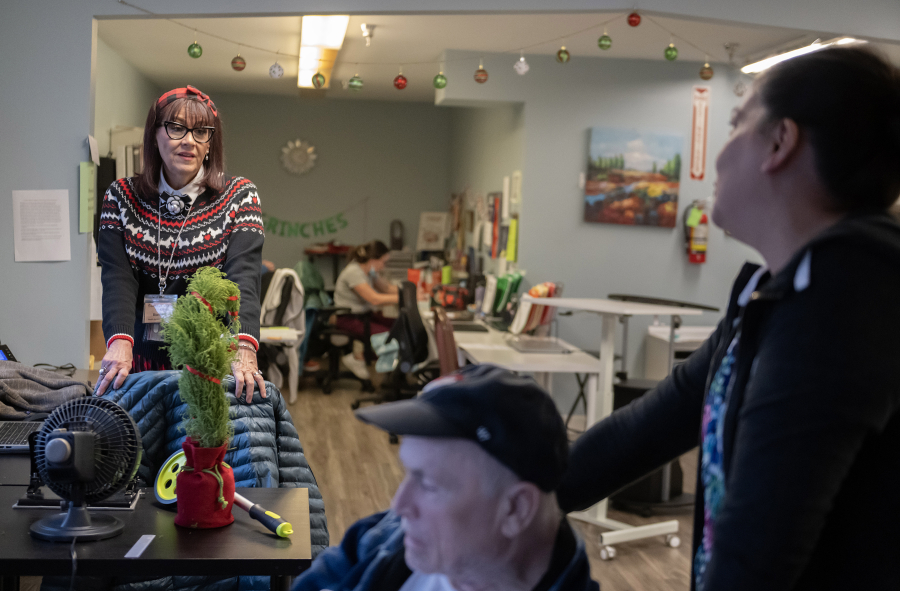 Dianna Kretzschmar, from left, of Vancouver Specialty and Rehabilitation Care pauses to talk with resident Danny Ellefson and colleague Melissa Allmaras on Dec. 4. (Amanda Cowan/The Columbian)