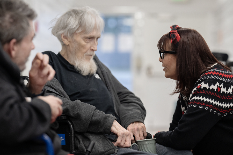 Richard Kalmbach, from left, and Robert Mullan pause to chat in the hallway with regional health services liaison Dianna Kretzschmar at Vancouver Specialty and Rehabilitation Care on Dec. 4. (Amanda Cowan/The Columbian)
