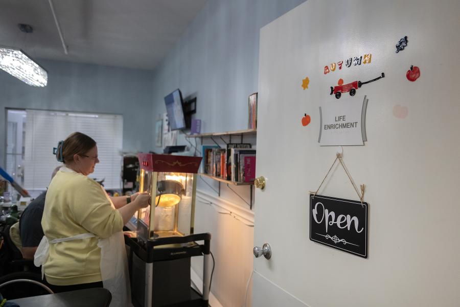 Melissa Munoz of Vancouver Specialty and Rehabilitation Care prepares fresh popcorn as residents watch a Christmas movie Dec. 4. (Amanda Cowan/The Columbian
Amanda Cowan/The Columbian)