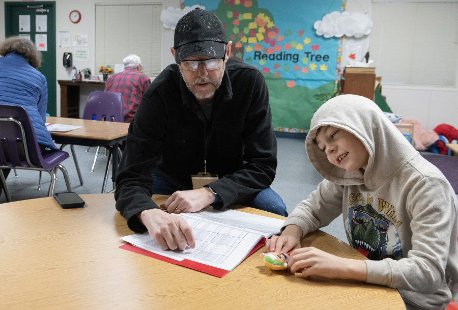 Reading mentor Lee Campen, left, works with third-grader Kellin Bartholomew, 8, during the Read Northwest program at Hathaway Elementary School on Dec. 8. Read Northwest is a nonprofit that helps children learn to read at their grade level with one-on-one support from a mentor. (Photos by Amanda Cowan/The Columbian)