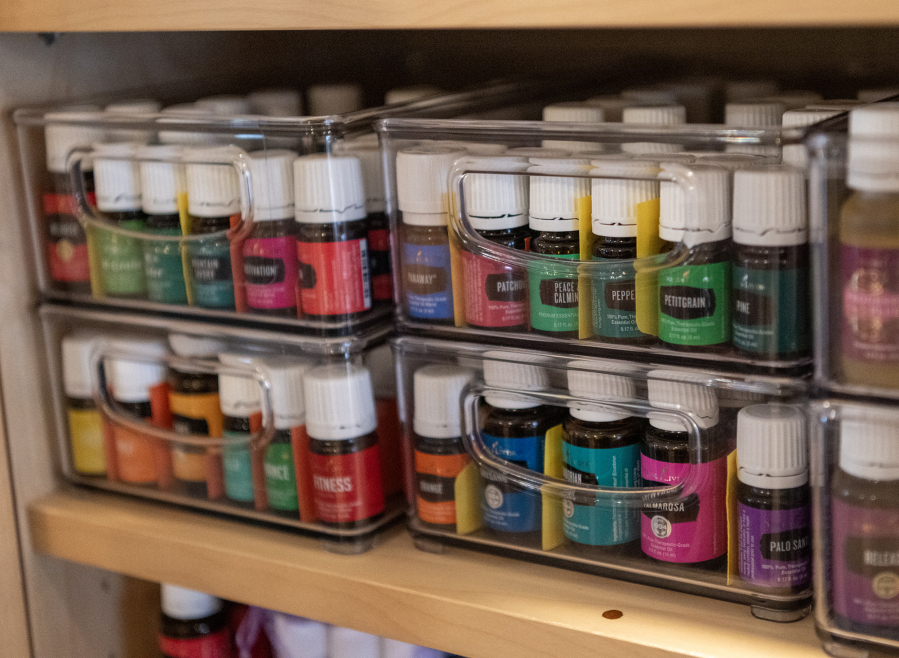 Yvonne Ye Gee, founder of the nonprofit wellness collective Embrace Qi, is a representative for Young Living, a company that sells natural wellness products containing essential oils. A huge selection of oils is displayed in a cabinet in a craft room at Rising Phoenix Farm in Washougal. (Taylor Balkom/The Columbian)