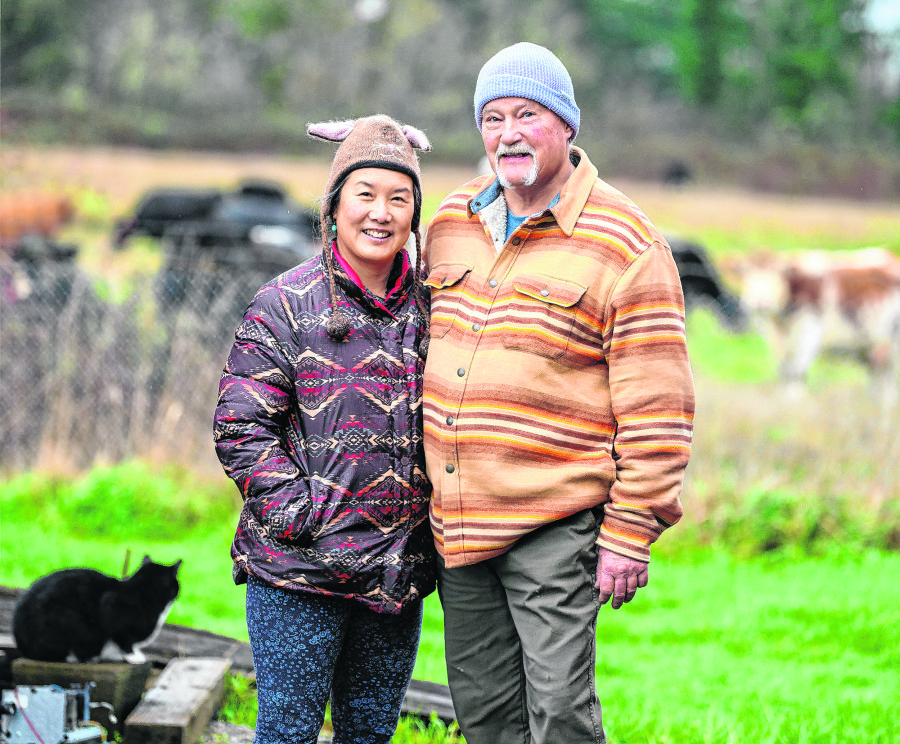 Yvonne Yeh Gee, left, and David Van Zandt stand for a portrait Dec. 19 at Rising Phoenix Farm in Washougal. Gee is the founder of the wellness collective Embrace Qi and Van Zandt is a painter and sculptor who works out of his huge hillside studio on the farm. The two are building a community of people to share their positive energy or &ldquo;qi.&rdquo; (Taylor Balkom/The Columbian)