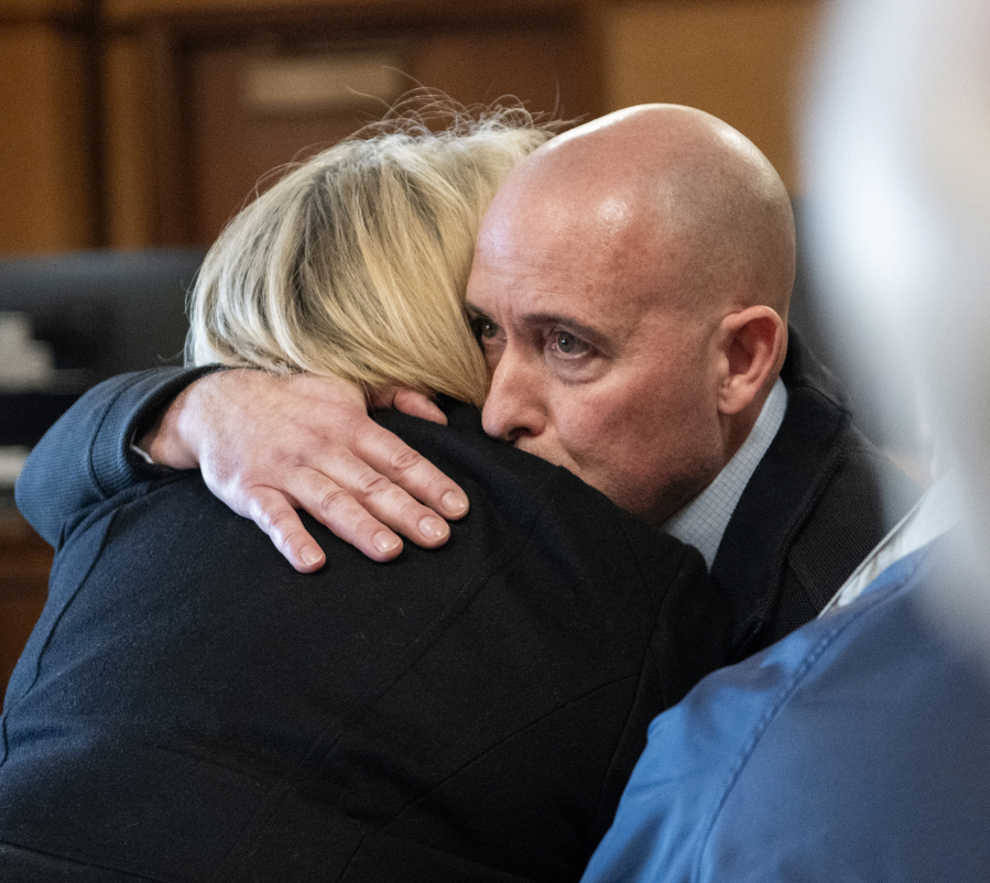 Former Camas-Washougal Fire Battalion Chief Kevin West, right, hugs a loved one Tuesday after a jury found West guilty of the murder of his wife at the Clark County Courthouse. (Taylor Balkom/The Columbian)