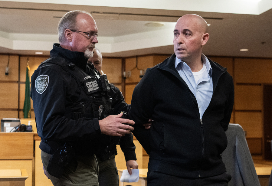 Former Camas-Washougal Fire Battalion Chief Kevin West, right, speaks to a member of the gallery as he is led away in handcuffs Tuesday after a jury found West guilty of the murder of his wife at the Clark County Courthouse. (Photos by Taylor Balkom/The Columbian)