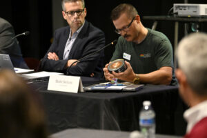 Washington State Energy Facility Site Evaluation Council member Blake Nelson, right, examines a cross-section of a transmission cable to be used in the Cascade Renewable Transmission project during a Nov. 17 public meeting at Black Pearl on the Columbia in Washougal. (Taylor Balkom/The Columbian files)
