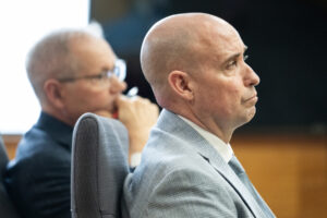 Former Camas-Washougal Fire Department battalion chief Kevin West, right, listens Jan. 6 to opening statements in Clark County Superior Court. (Taylor Balkom/The Columbian files)