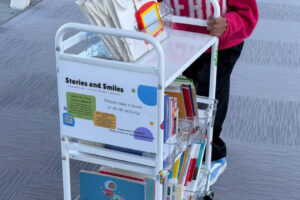 Nysa Vinod, a 14-year-old Camas eighth-grader, pushes one of her Stories and Smiles carts in an Evergreen Pediatrics Clinic location in Vancouver. (Vinod Vijayan)