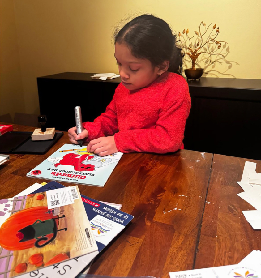 Nysa Vinod prepares a book for one of her Stories and Smiles carts at her Camas home. (Vinod Vijayan)