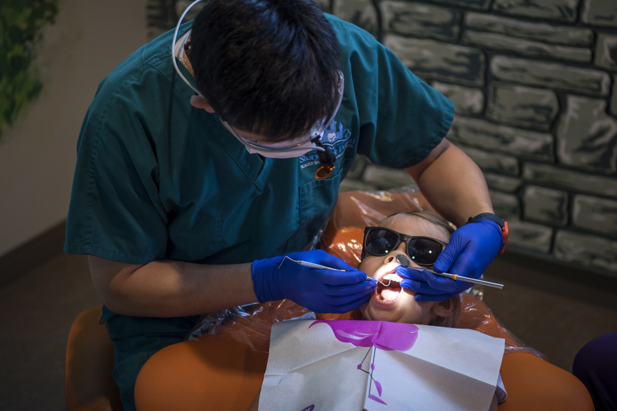 Dr. Ron Hsu treats a patient in 2018 at Storybook Dental in Camas. (The Columbian files)