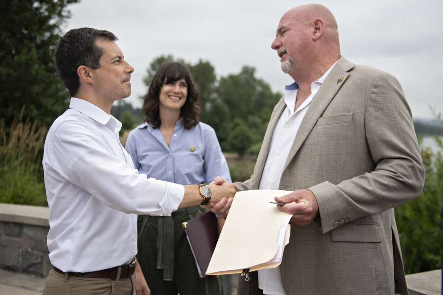 Then-U.S. Secretary of Transportation Pete Buttigieg, from left, speaks with U.S. Rep. Marie Gluesenkamp Perez and Washougal Mayor David Stuebe at the Port of Camas-Washougal on July 7, 2023. (Amanda Cowan/The Columbian files)