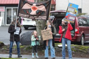Members of the Camas Friends Church hold signs during a protest rally on Third Avenue in Camas on Feb. 18. The church has been demonstrating weekly to protest federal immigration enforcement actions. (Doug Flanagan/The Columbian)