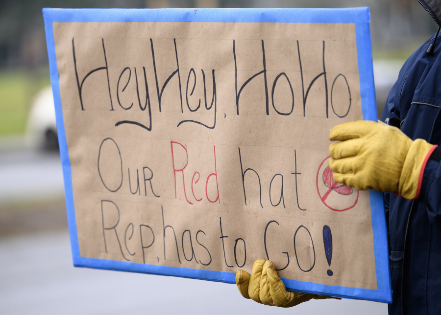 Protester Joe Ault, of Vancouver, holds a sign Wednesday outside the offices of Rep. Marie Gluesenkamp Perez, D-Skamania, on Officers Row.