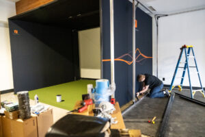 Trackman worker Dominic Miller installs one of two indoor golf simulators Tuesday at Camas Indoor Golf Club in Camas. (Taylor Balkom/The Columbian)