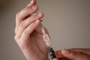 Student medical assistant Megan Kivari extracts a vaccine from a bottle July 23 at Kaiser Permanente&rsquo;s Cascade Park Medical Office. (Taylor Balkom/The Columbian files)