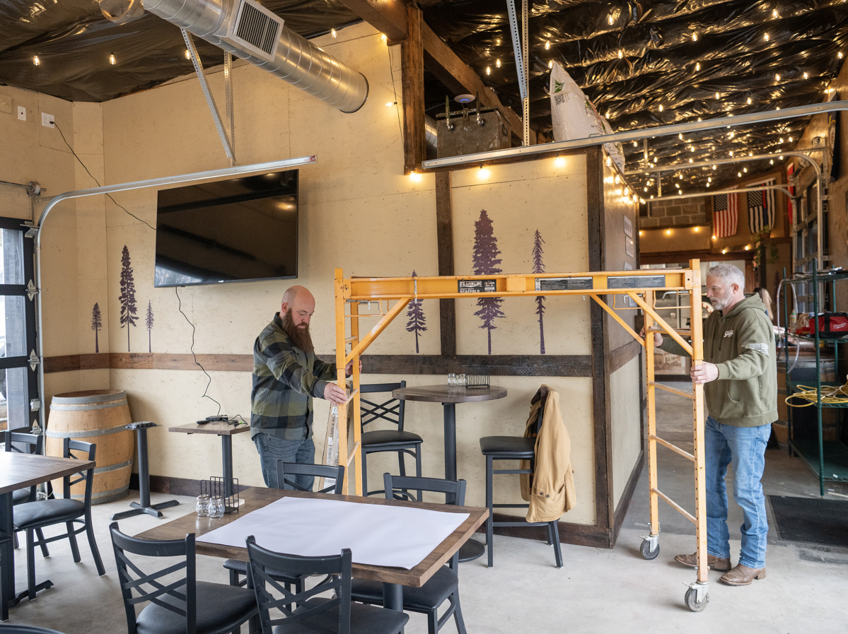 Owners Jon Borth, left, and Rod Edwards move scaffolding on Monday at Shoug&rsquo;s Draft House in Washougal. (Photos by Taylor Balkom/The Columbian)