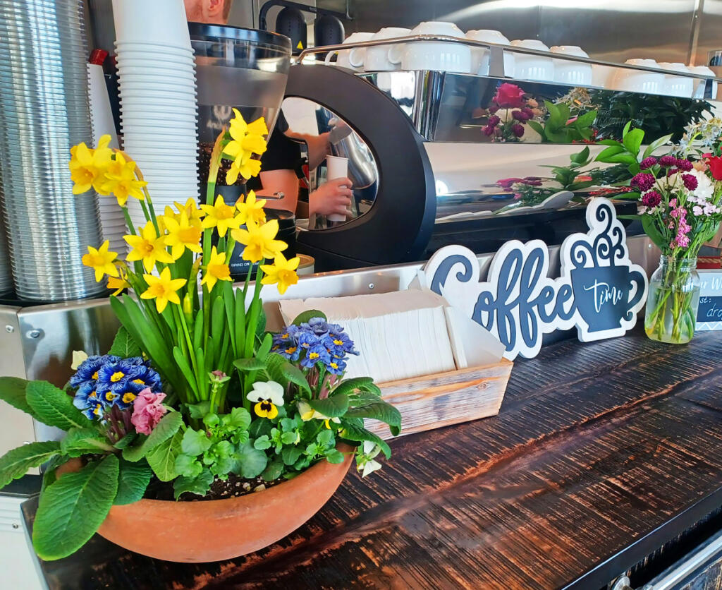 The coffee counter at Drop Anchor Bistro is flanked by spring blooms. Co-owner Cindy Hillard bakes big, chewy oatmeal cookies with local cranberries and coconut.