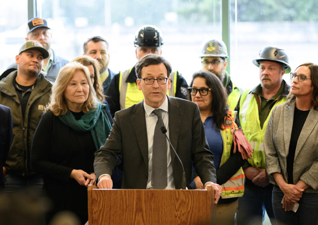 Washington Gov. Bob Ferguson, center, speaks at a press conference Tuesday at the Interstate Bridge Replacement Program headquarters in downtown Vancouver.