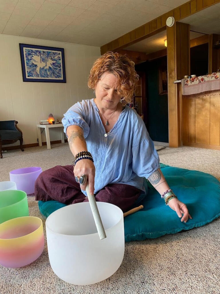 Each of Rachel Fouts-Carrico&rsquo;s crystal singing bowls is attuned to a different chakra, or body&rsquo;s energy center in yogic teaching. Here, Fouts-Carrico plays the &ldquo;root chakra&rdquo; bowl. (Contributed photo)
