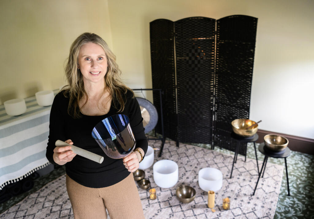 Andrea Kintzley demonstrates a handheld singing bowl at her studio, Soul Space Wellness. (Taylor Balkom/The Columbian)