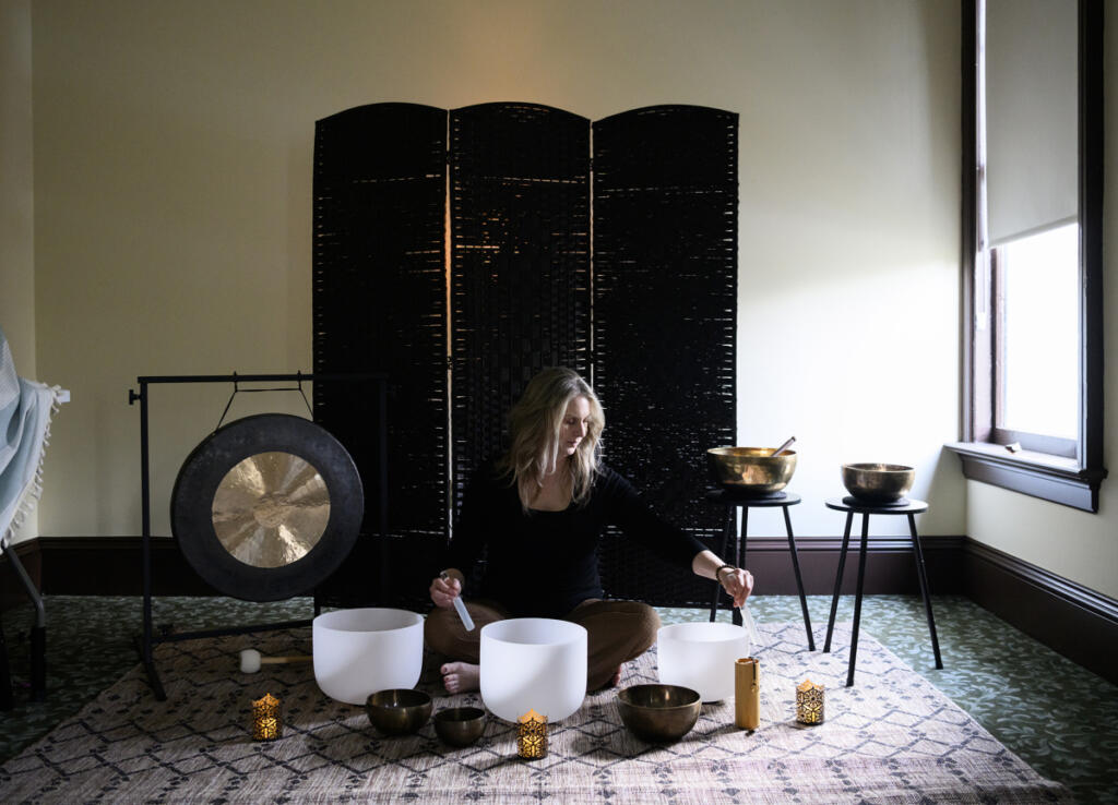 Andrea Kintzley demonstrates crystal singing bowls and other sound therapy instruments March 10 at Soul Space Wellness in the O.O. Howard House. Kintzley offers regular sound baths in response to the increased interest in sound healing. (Taylor Balkom/The Columbian)